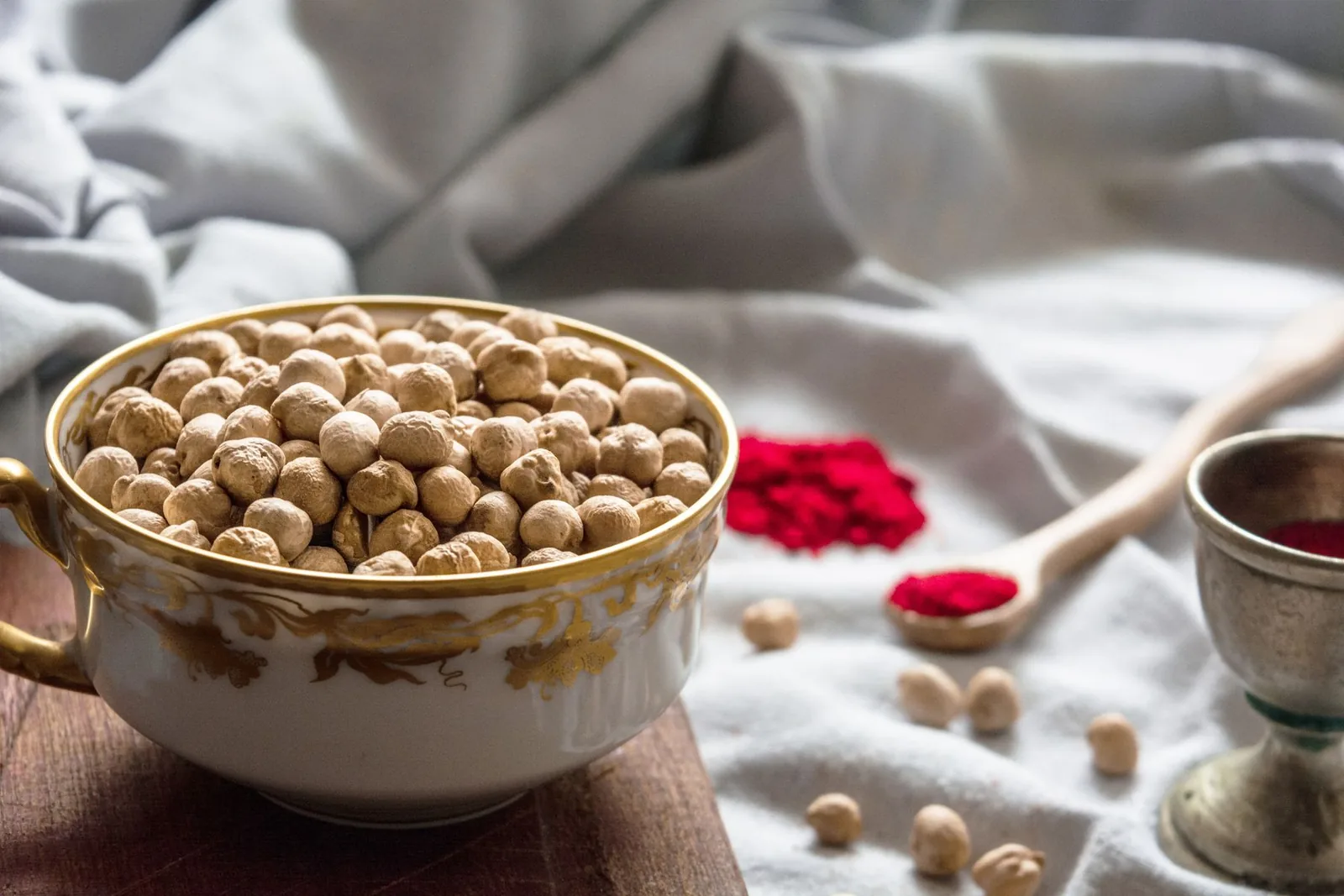 Un bol de pois chiches secs à côté d’épices.